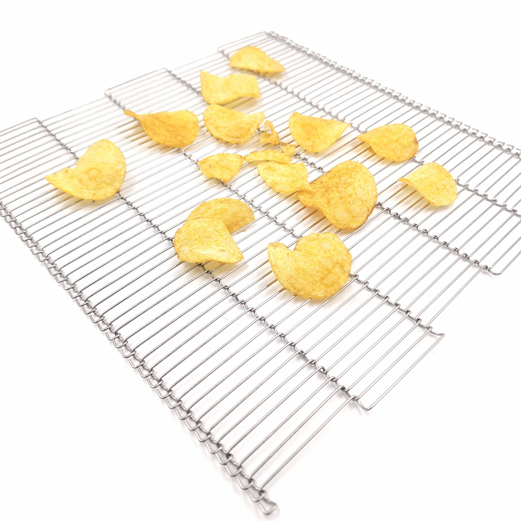 Golden curved chips displayed on an open ladder-style metal conveyor belt.