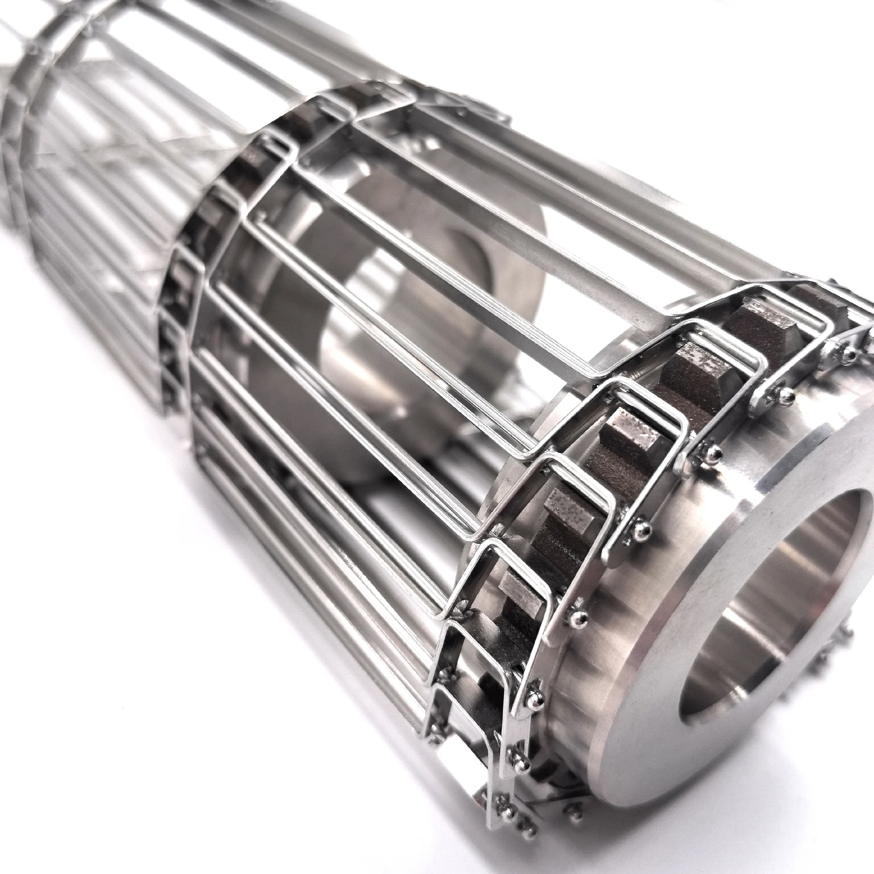 Close-up of a metal conveyor belt edge positioned against a machined sprocket tooth profile.