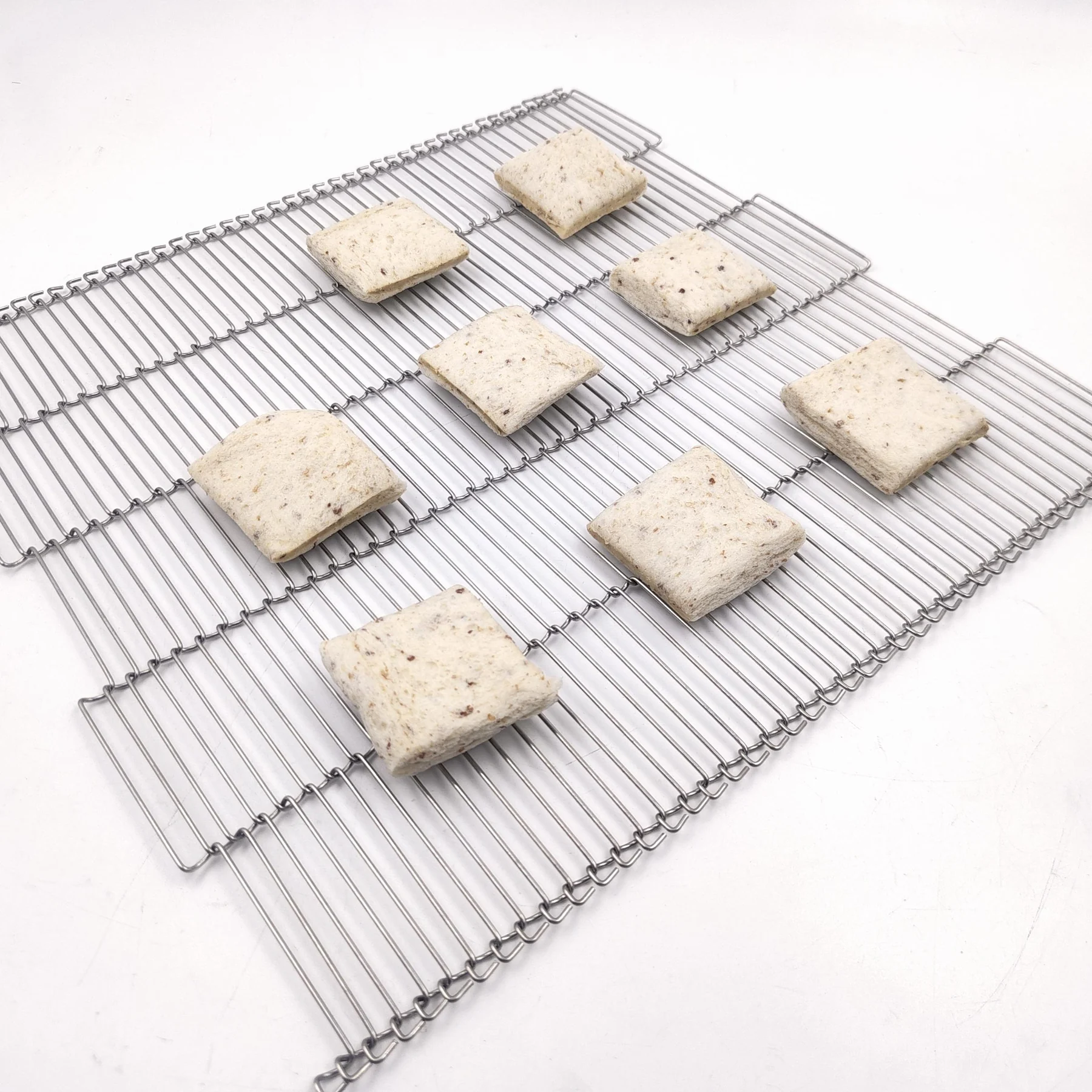 Square prepared food portions displayed on a Z-Type Ladder Belt, also known in searches as a trapezoidal mesh belt.